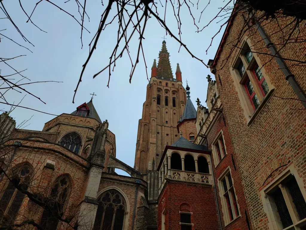 Low-angle view of the Gothic Church of Our Lady in Bruges, showcasing historical Belgian architecture.