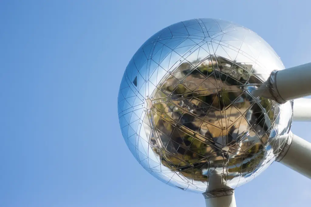 Close-up view of Atomium in Brussels, showcasing its reflective metallic surface against a clear blue sky.