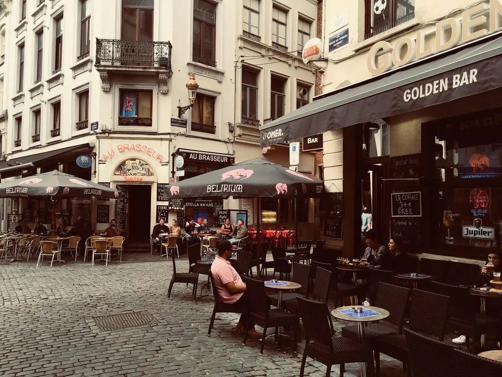 Outdoor cafes in a historic Brussels street, capturing the vibrant city life and European architecture.