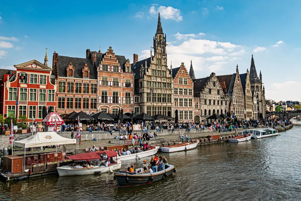 Beautiful day at Graslei, Ghent with historic buildings and vibrant activity along the river.