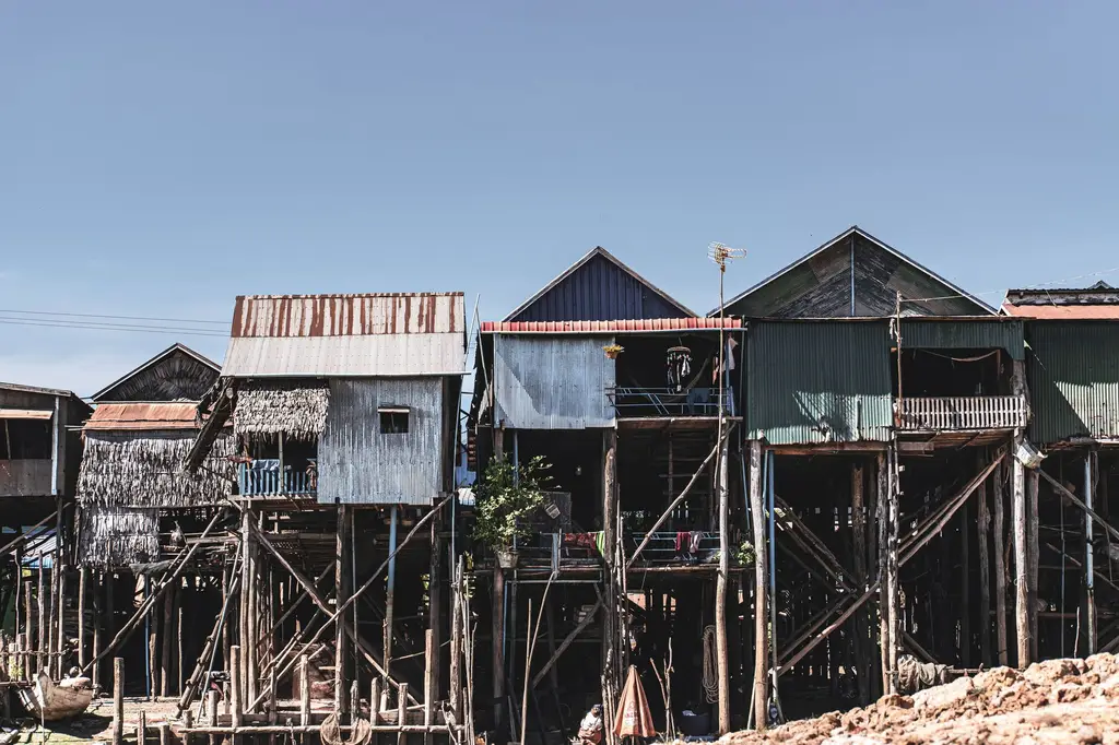 Stilt houses in Kampong Phluk, Siem Reap, showcasing traditional architecture against a clear sky.