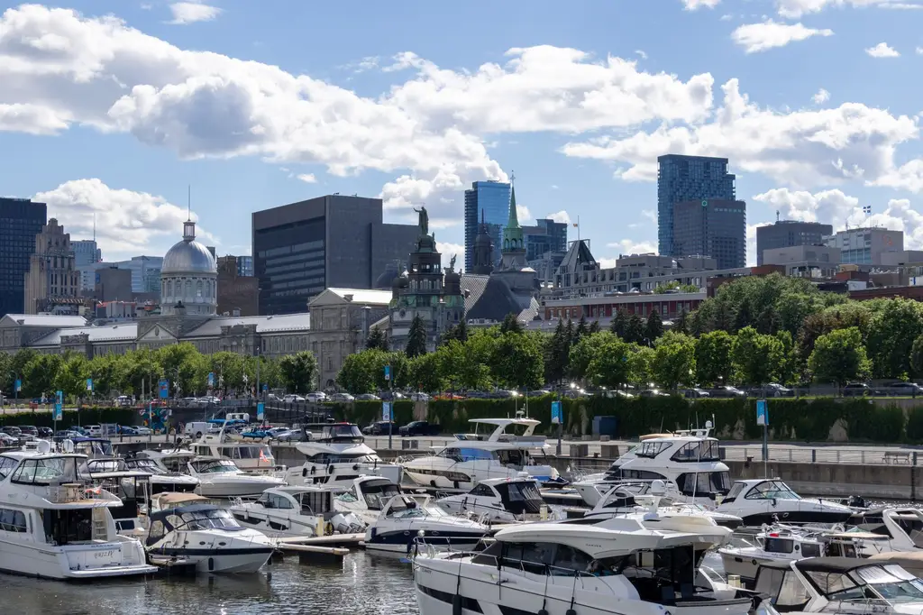 Beautiful view of Montreal's Old Port marina with city skyline and boats on a sunny day.