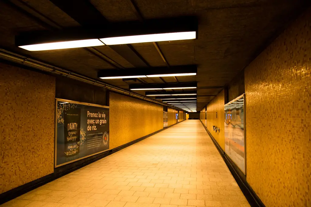 A warm lit underground metro tunnel with yellow tiles in Montreal, Canada, creating a moody atmosphere.