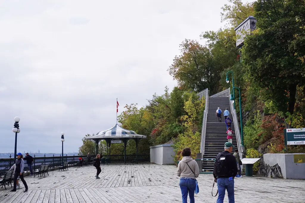 People enjoying the fall view at Terrasse Dufferin with staircase and gazebo in Quebec City, Canada.