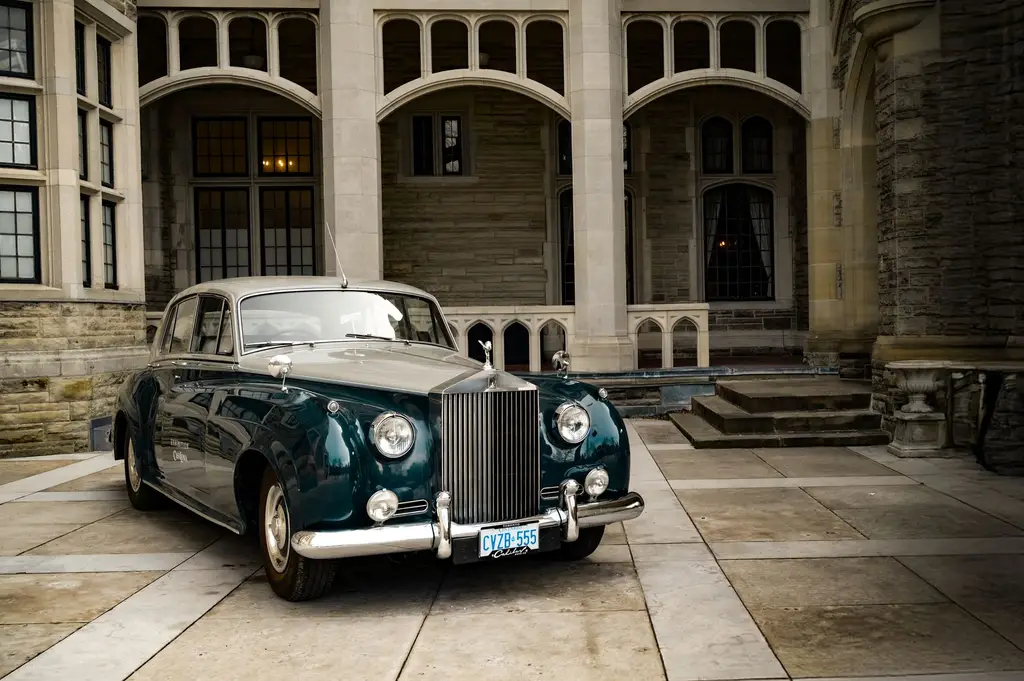 A classic Rolls-Royce parked outside Casa Loma in Toronto, Ontario, a popular historical landmark.