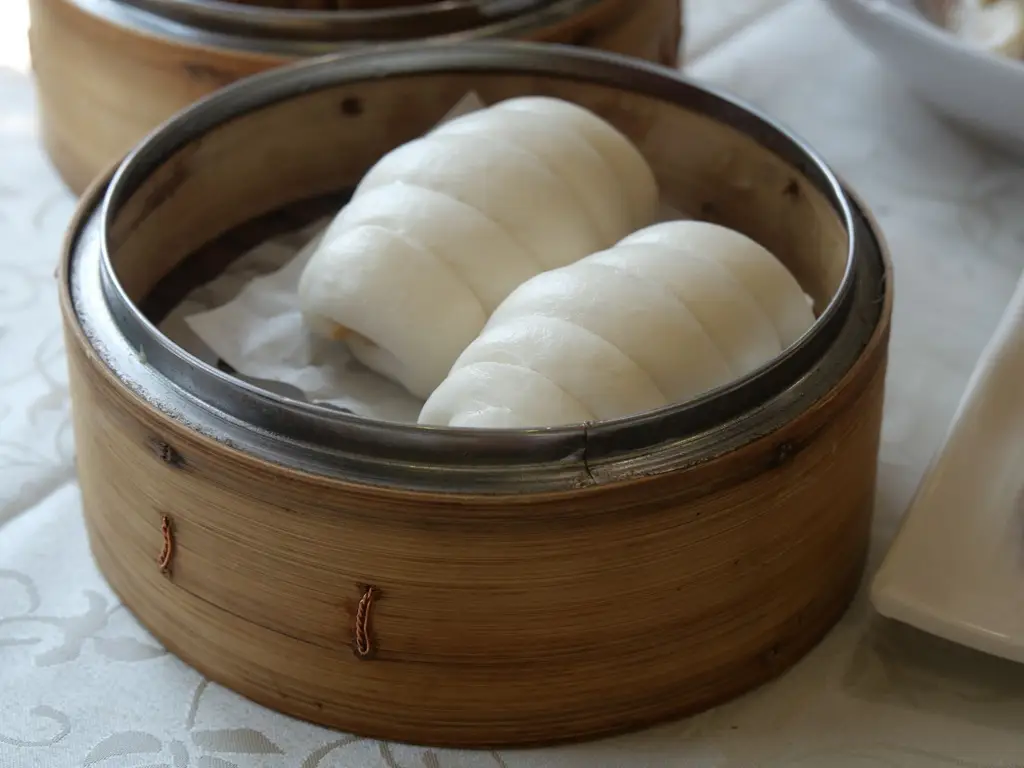 Close-up of delicious steamed Chinese buns in a bamboo steamer for dim sum cuisine enthusiasts.