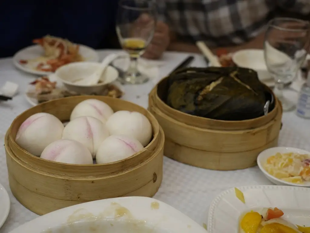 A selection of dim sum in bamboo steamers on a restaurant table, showcasing traditional Asian cuisine.