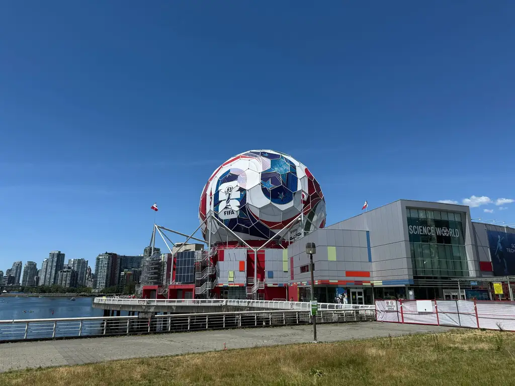 A vibrant view of Science World and surrounding cityscape in Vancouver with clear blue sky.