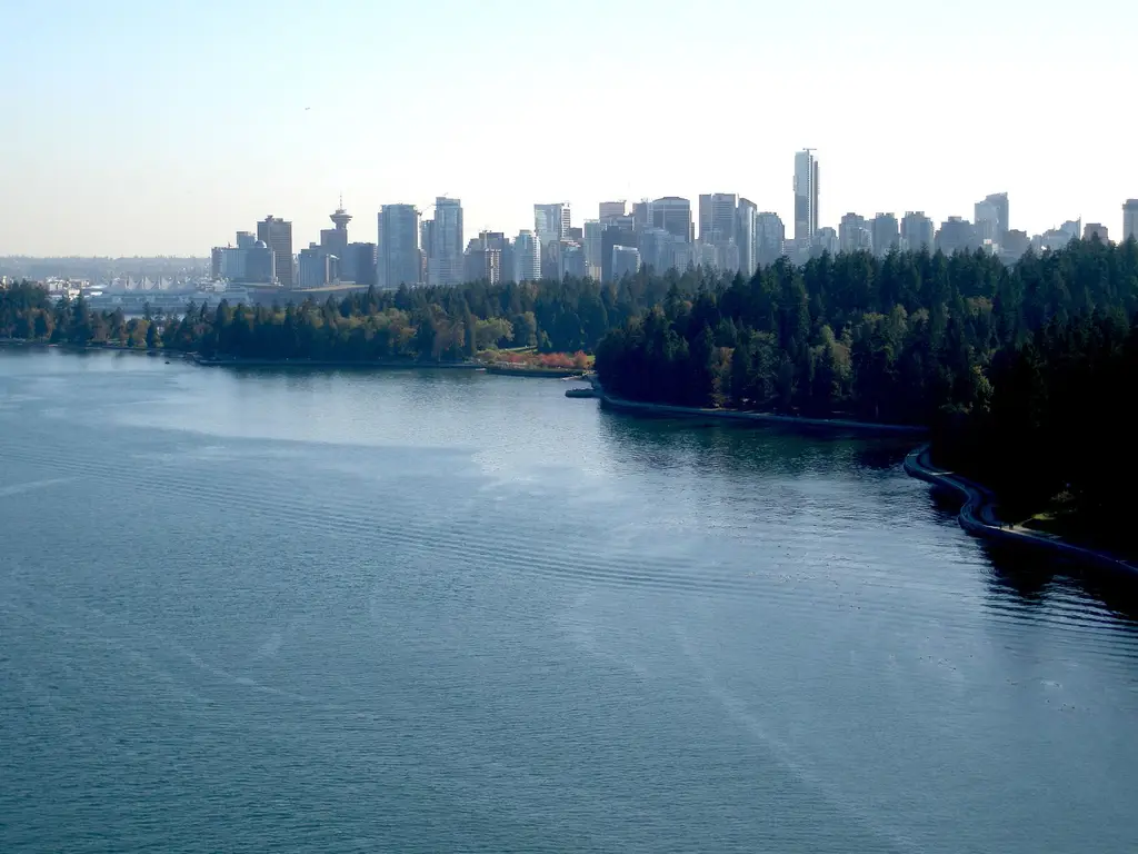 An aerial view of Vancouver's skyline with Stanley Park and water in the foreground.