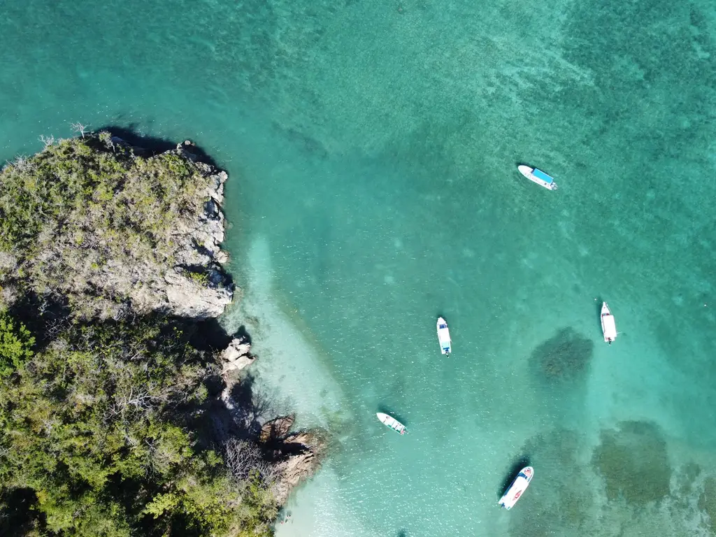 Aerial shot of boats floating in clear turquoise waters off the coast of Costa Rica.