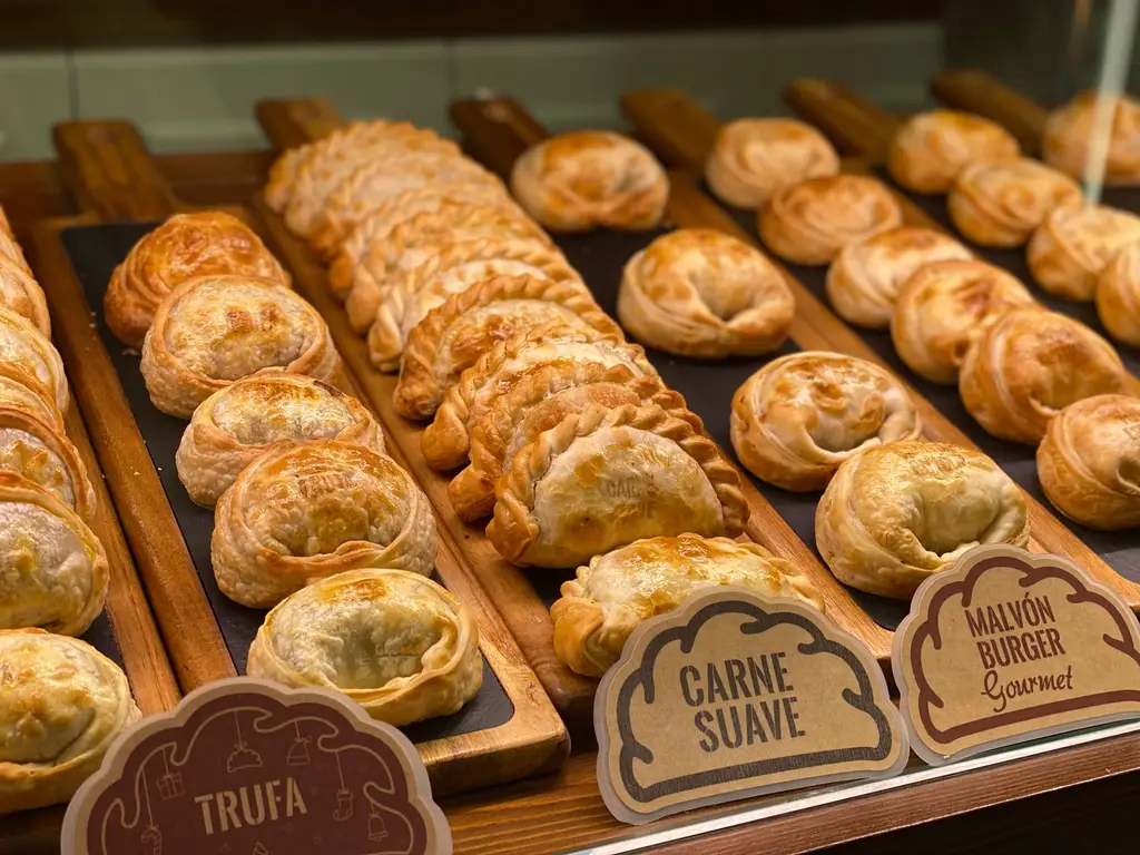 Delicious assortment of freshly baked empanadas on display in a bakery setting.