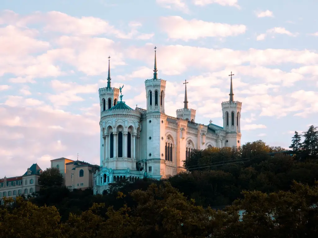 A stunning view of the Basilica of Notre-Dame de Fourvière in Lyon, France, during sunset.