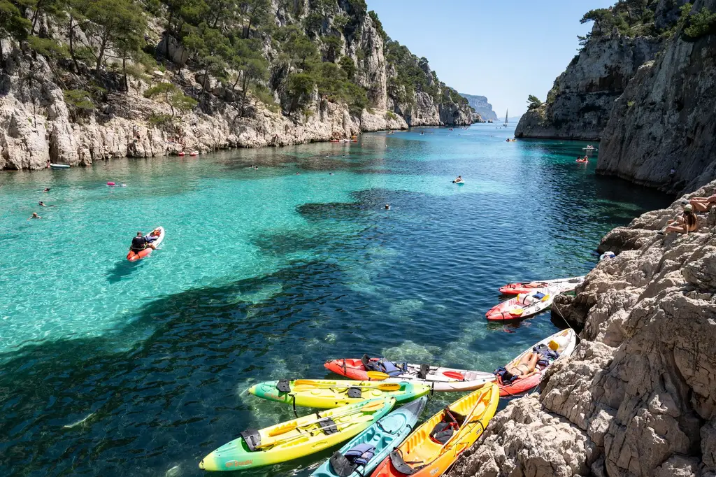 Explore the stunning Calanques in Marseille, France with vibrant kayaks and clear waters, perfect for adventure lovers.