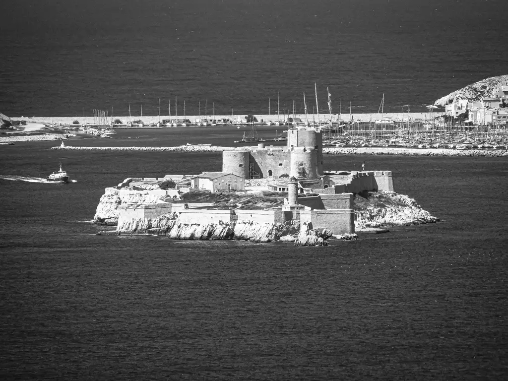 Aerial black and white photo of Château d'If on a small island near Marseille, France.