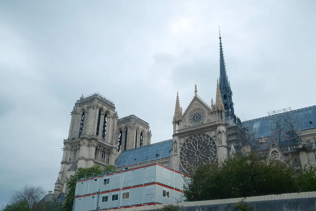 A view of the iconic Notre-Dame Cathedral in Paris under restoration, captured on a cloudy day.