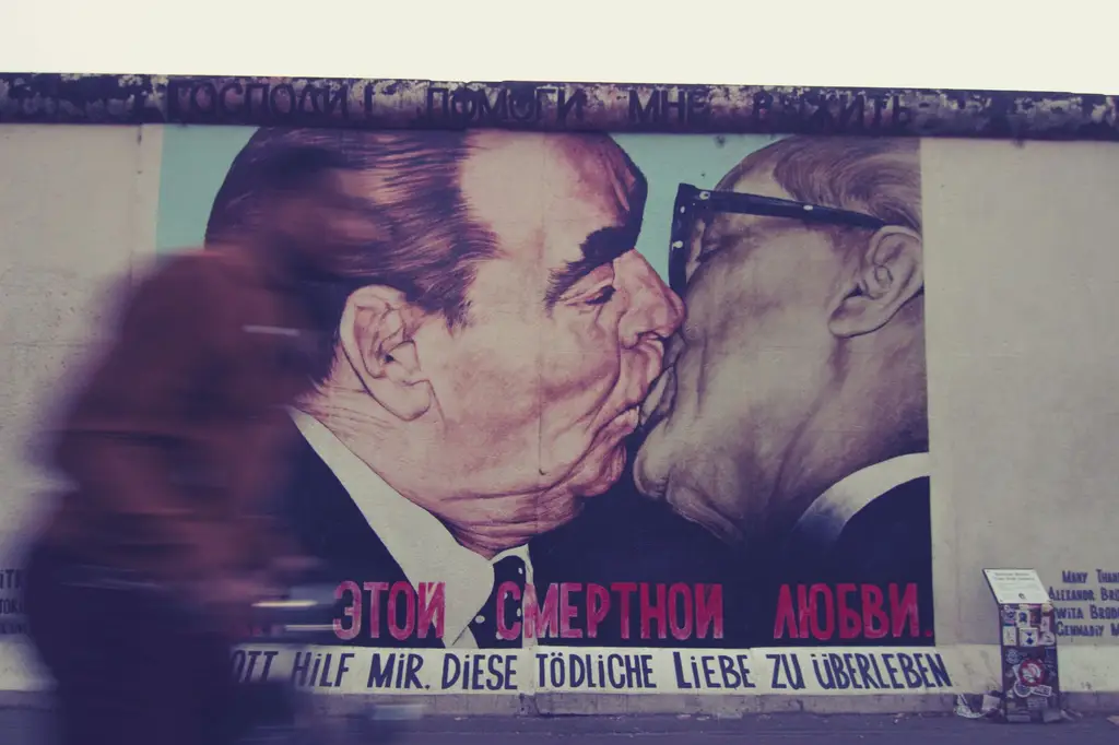 Iconic mural of political figures kissing at Berlin Wall's East Side Gallery.