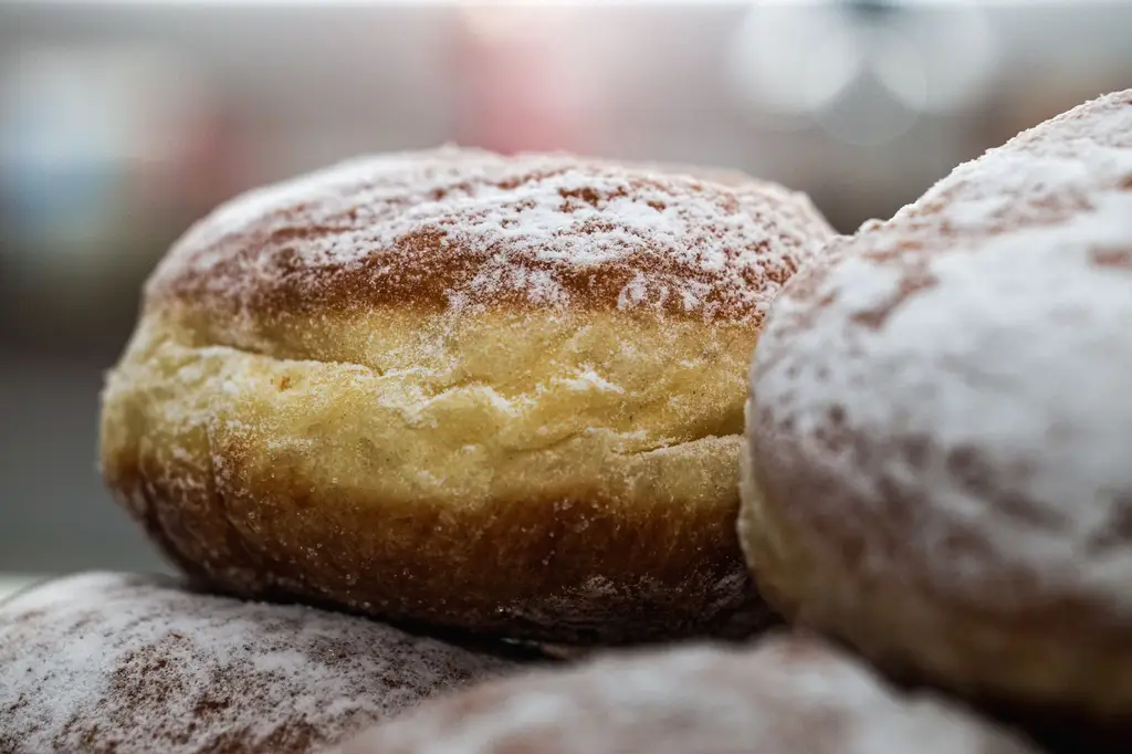 Close-up of freshly baked Berliner donuts with powdered sugar. Ideal for food and culinary content.