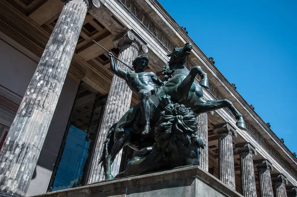 Low angle of a bronze horse and rider statue at the Altes Museum, Berlin on a sunny day.