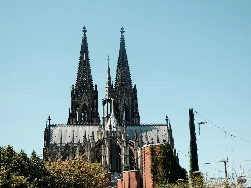 The iconic spires of Cologne Cathedral under a clear blue sky.