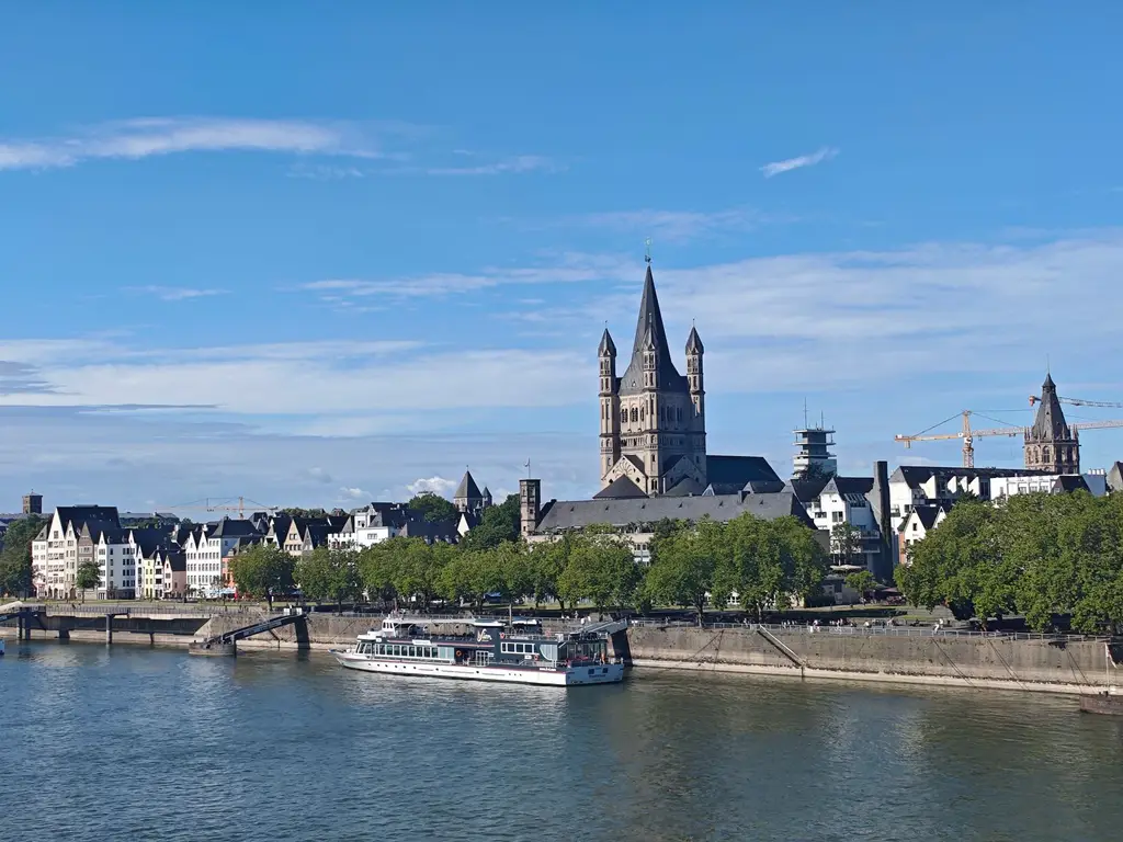 Beautiful Cologne riverside with Great St. Martin Church and ship on the Rhine River.