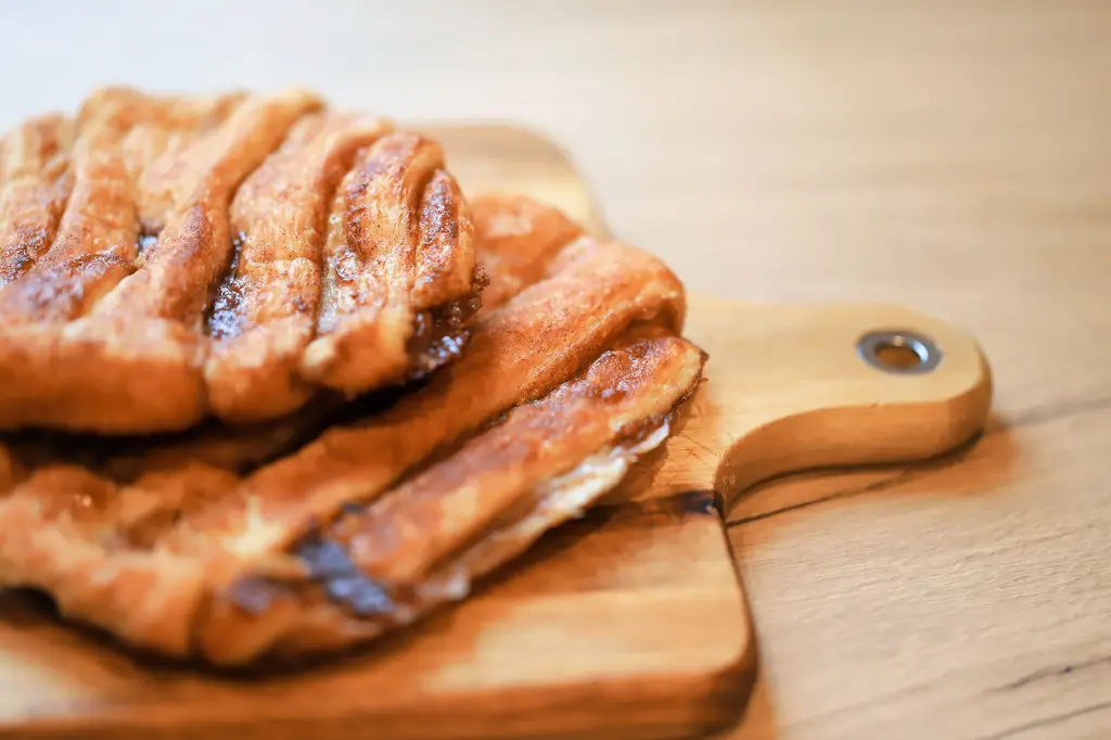Delicious cinnamon pastry on a wooden board, perfect for sweet lovers.
