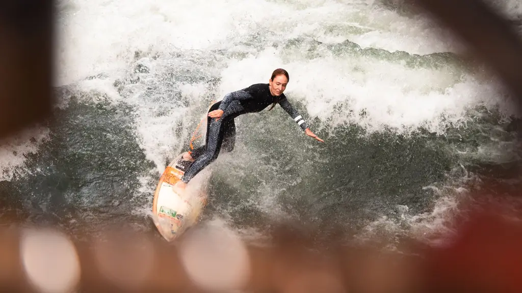 A skilled surfer conquers the waves on the Eisbach River in Munich. Action-packed water sports.