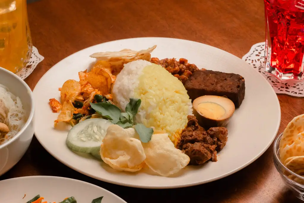 Indonesian Nasi Campur with rice, egg, tempeh, and vegetables, beautifully plated.