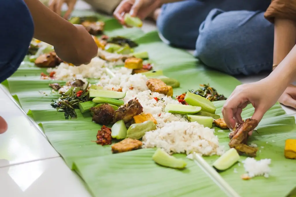 nasi liwet, indonesian food, banana leaf, tradition, tofu, tempeh, fried chicken, sambal paste, water spinach, food gathering, culture, family dinner, hands, shared meal, traditional cuisine, indonesian culture, fresh food, simplicity, indonesian cooking, communal dining