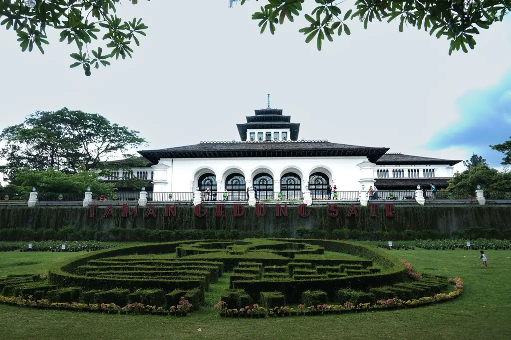Scenic view of Gedung Sate, a historic government building in Bandung, surrounded by lush greenery.