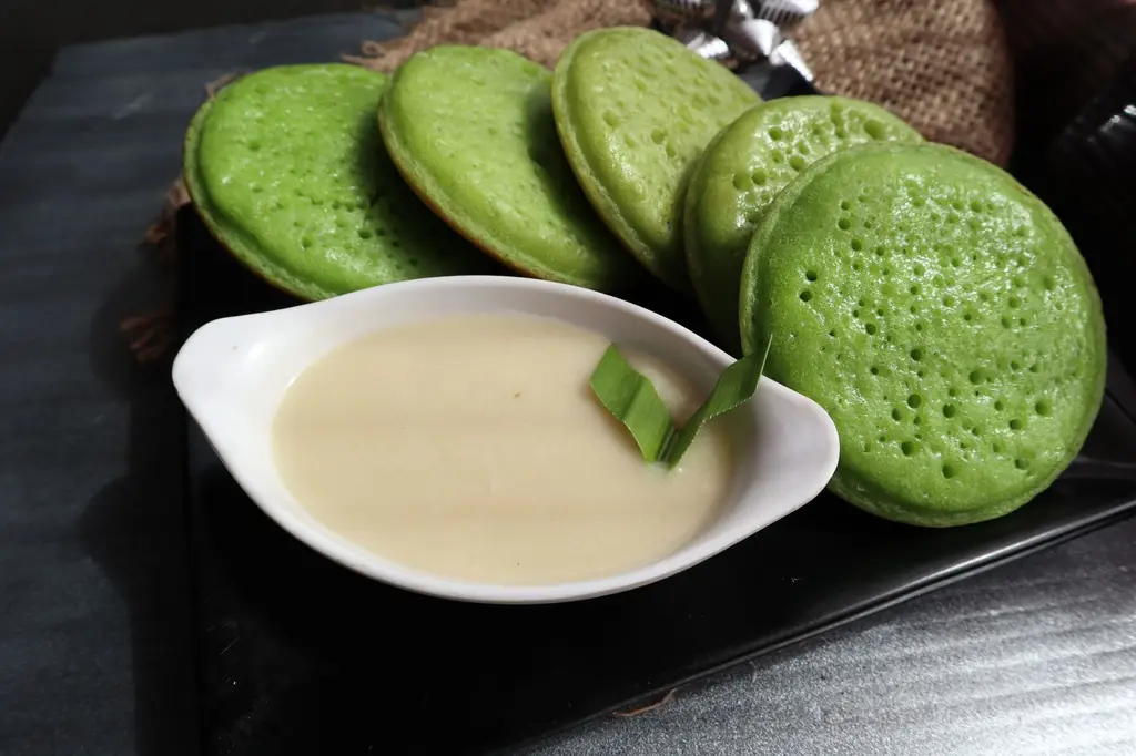 Close-up of Indonesian Serabi pancakes with a coconut sauce, highlighting a traditional sweet Asian cuisine.