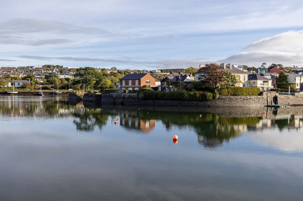 Charming houses reflect in the calm waters of Kinsale, County Cork, Ireland.