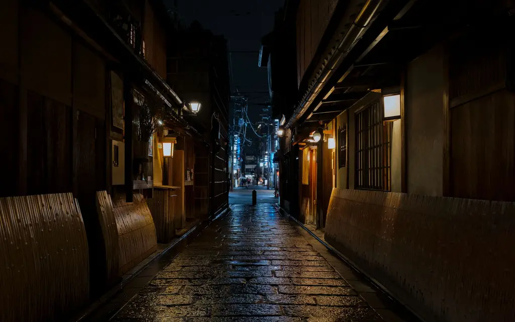 Explore a desolate and traditional street in Kyoto's Gion district on a moody rainy night.