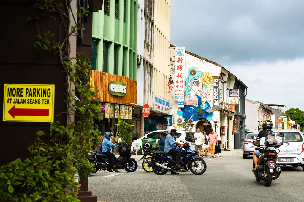 Vibrant street scene in George Town, Penang with motorbikes and colorful murals.