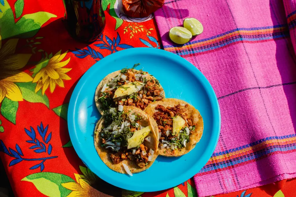 Delicious Mexican tacos with toppings on a colorful table setting in Mexico City.