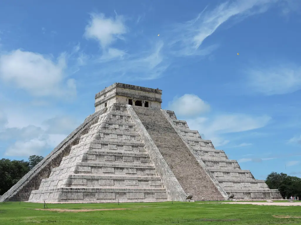 El Castillo pyramid at Chichen Itza in Mexico, showcasing ancient Maya architecture under a bright blue sky.