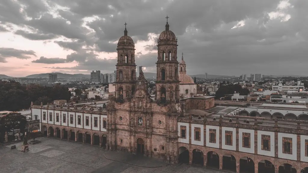 A stunning aerial view of a historic cathedral under dramatic skies at dusk.