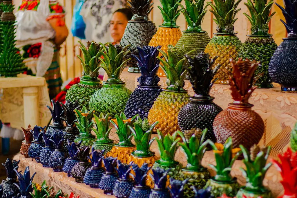 Colorful handcrafted pineapple-shaped pottery on display in Michoacán, Mexico's vibrant market.