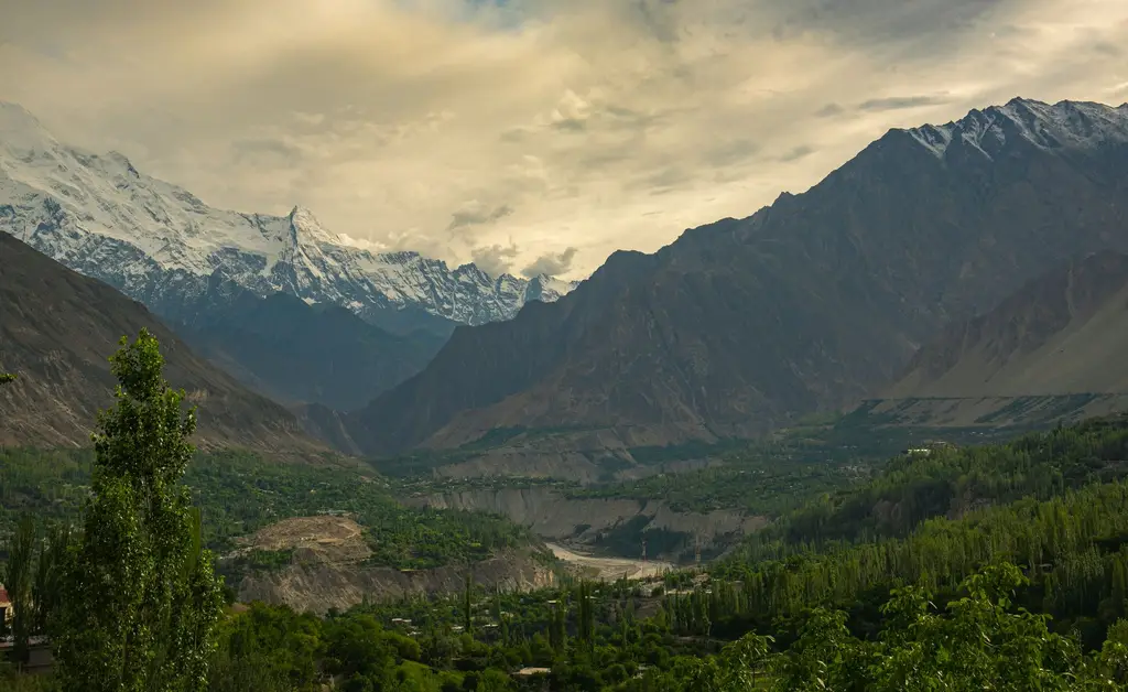 Breathtaking view of Hunza Valley with lush greenery and snow-capped peaks.