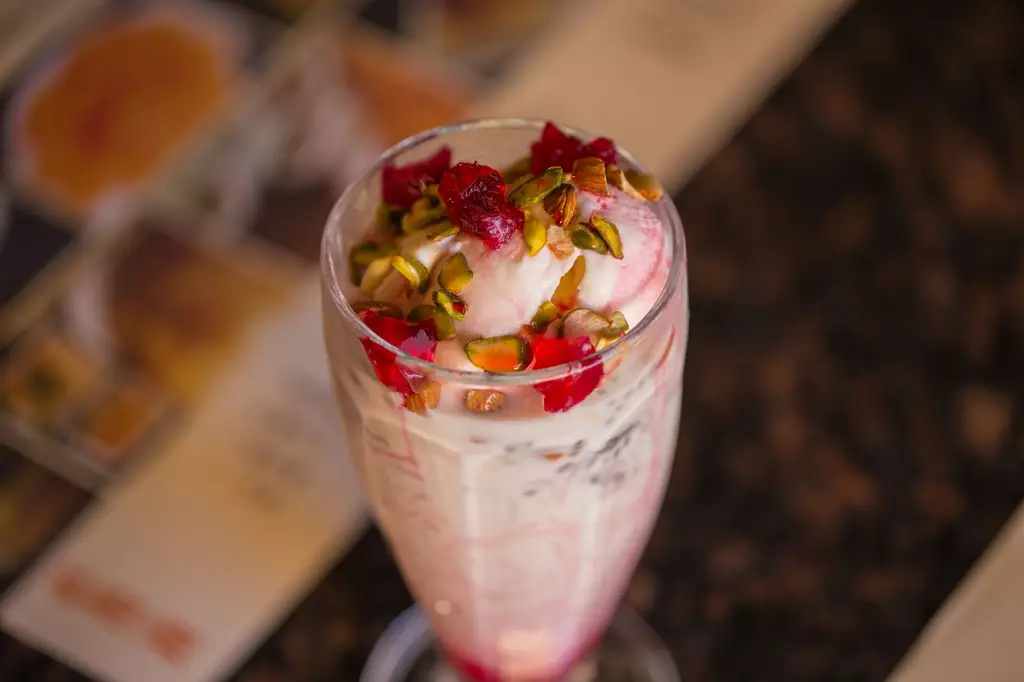 A tempting glass of falooda topped with pistachios and rose syrup, captured elegantly in Dubai.