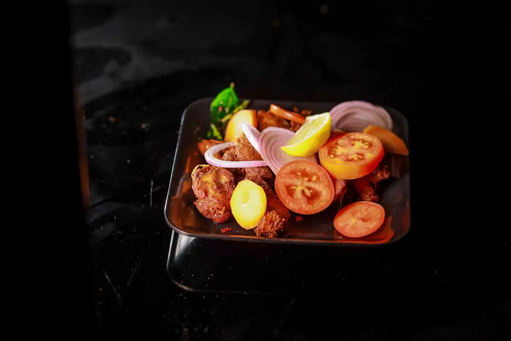 a plate of food with tomatoes, onions, and meat