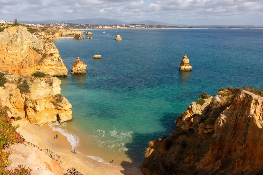 Beautiful aerial view of Praia do Camilo, Lagos, with golden cliffs and turquoise waters in Algarve, Portugal.