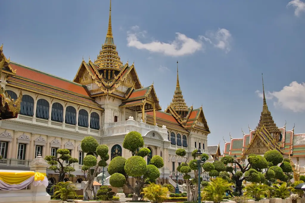 Ornate thai palace with golden spires and manicured gardens