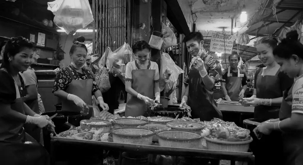 Workers cutting meat or fish in Khlong Toei market, Bangkok