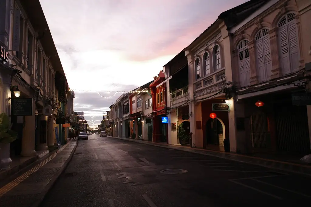 Charming colonial street in Phuket Town at dusk with vibrant architecture and atmospheric lighting.