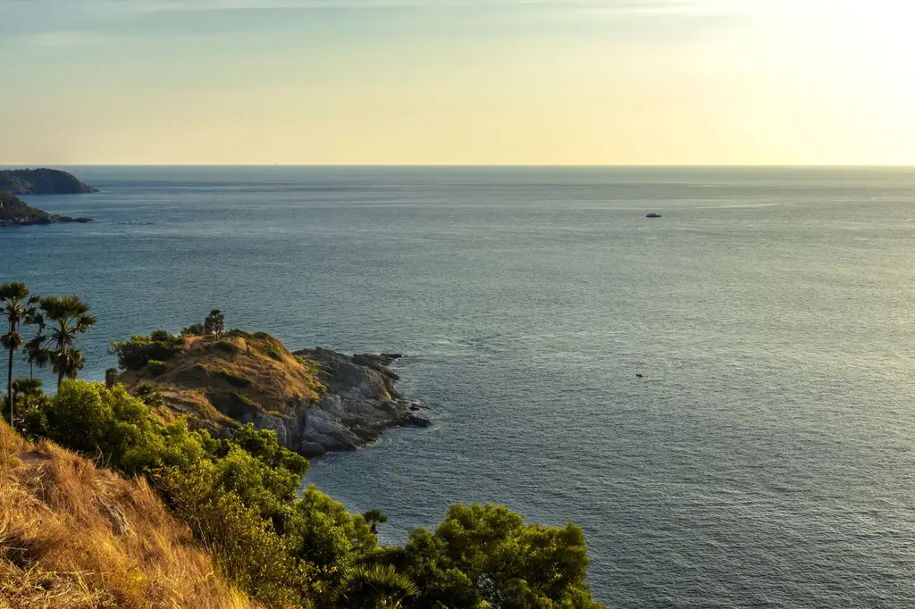 Breathtaking view of the sea and lush greenery at sunset from Promthep Cape in Phuket, Thailand.