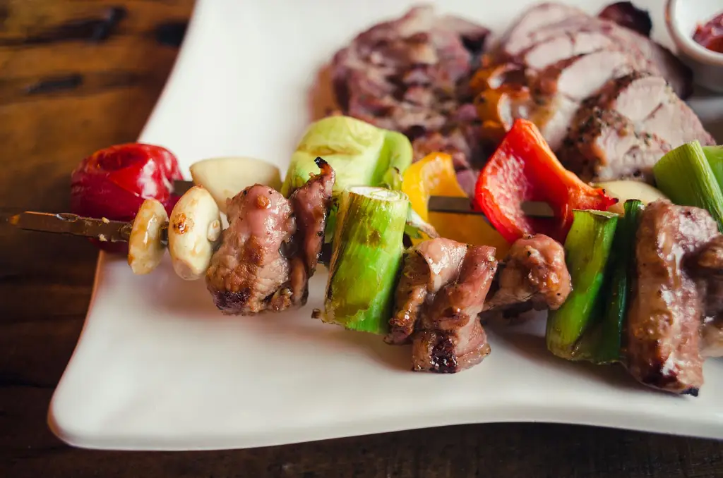 Tasty grilled meat and vegetable skewer on a white plate, perfect for BBQ enthusiasts.