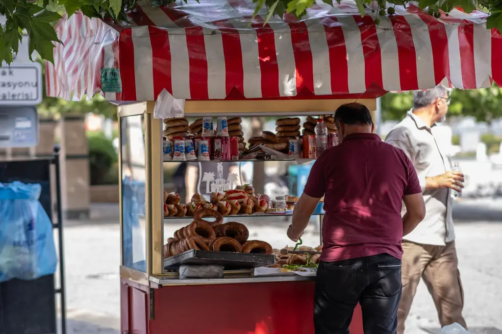 A street vendor sells traditional simit in a market booth in İzmir, Turkey.