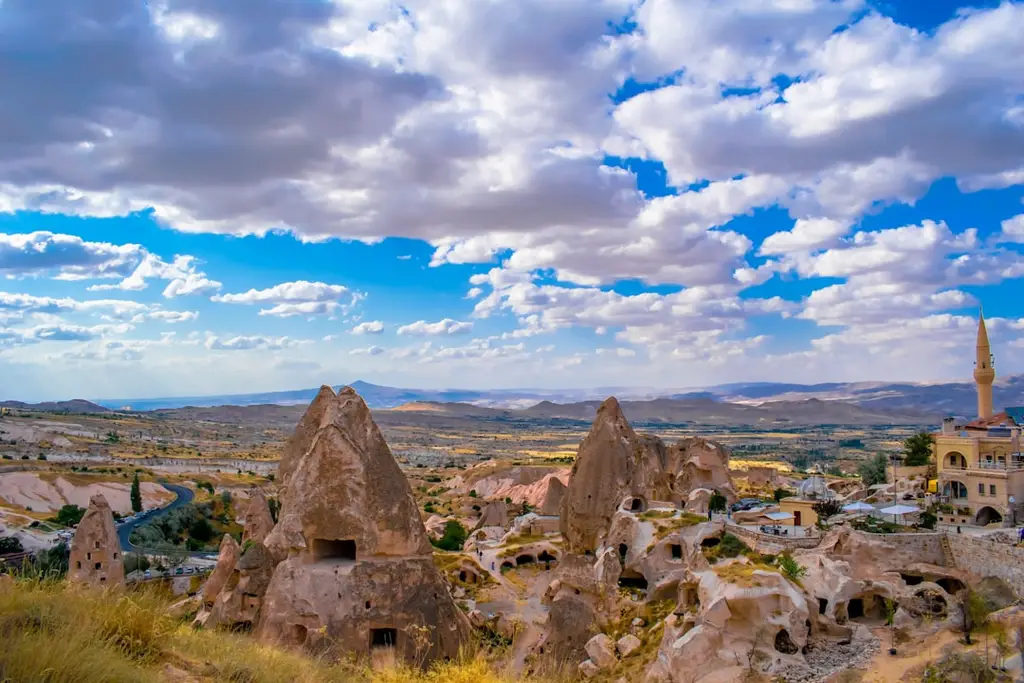 a scenic view of a city with mountains in the background