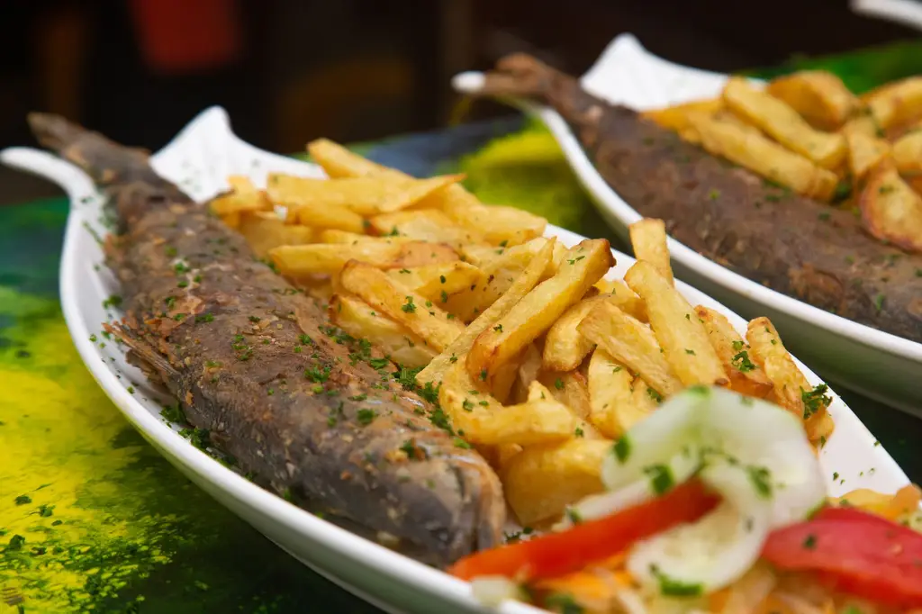 Close-up of a savory fish and chips dish garnished with fresh herbs, highlighting traditional flavors.