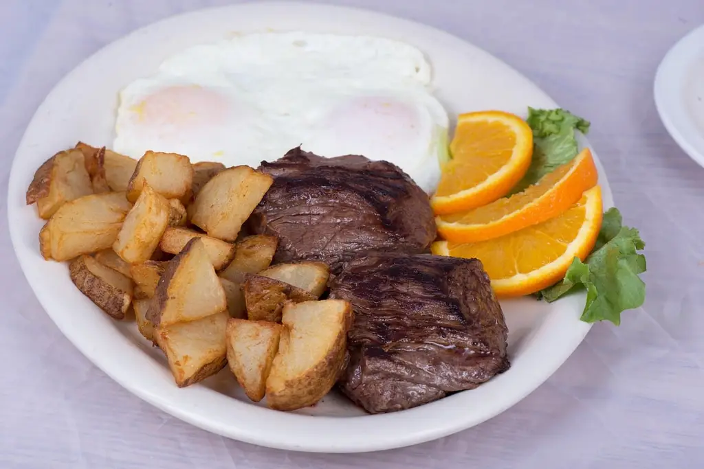 steak, eggs, home fries, american breakfast, orange slices, breakfast, brunch, grilled steak, beef, restaurant, diner, comfort food, homemade, cooked breakfast, protein, delicious, food photography, breakfast plate, fresh food